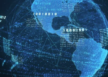 A digitally rendered image of the Earth with a focus on the Americas, surrounded by a network of glowing blue lines and binary code, symbolizing global digital connectivity and data exchange, highlights an exploration of what are digital assets in our interconnected world. | COYYN