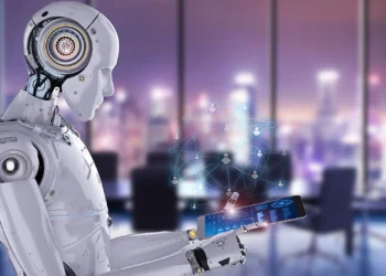 A humanoid robot with a sleek white design interacts with a futuristic touchscreen tablet emitting a holographic network of interconnected people icons, symbolizing the dynamic between Robo-Advisors vs. Human Advisors. The background features a modern office with large windows overlooking a cityscape with blurred lights. | COYYN
