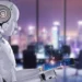 A humanoid robot with a sleek white design interacts with a futuristic touchscreen tablet emitting a holographic network of interconnected people icons, symbolizing the dynamic between Robo-Advisors vs. Human Advisors. The background features a modern office with large windows overlooking a cityscape with blurred lights. | COYYN