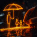 A glowing orange sketch depicts a hand holding a pen drawing a scene of three figures beneath an umbrella. The figures, two children and one adult, stand under the umbrella, appearing protected from potential rain. This illustration, much like Automated Underwriting in Life Insurance, offers a sense of security and warmth with its neon effect. | COYYN
