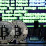 Two physical Bitcoin coins stand upright on a computer motherboard, with blurred green and blue computer code in the background, symbolizing cryptocurrency mining and the role of crypto exchanges in digital asset transactions. | COYYN