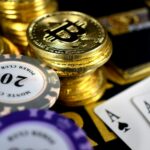 Stacks of gold Bitcoin coins, poker chips, and two aces are arranged on a casino table, highlighting the excitement and risk-taking atmosphere of Bitcoin Casinos. | COYYN