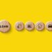 Five wooden circles on a yellow background, with icons representing "loan," money, a calendar, a house, and a car, symbolizing different types of loans and financial concepts. | COYYN