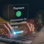 Hands typing on a laptop keyboard with a floating digital payment form overlay, showing card details and a green shield icon—suggesting secure online payment and highlighting 3 important things players should know before signing up to a new online casino. | COYYN