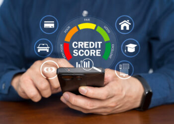 A person using a smartphone is shown with a digital credit score gauge on-screen, ranging from "very poor" to "excellent," along with icons for a car, home, computer, card, loan, and education. | COYYN
